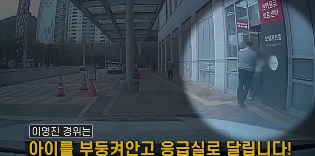 Ltd. Lee Yeong-jin from the U-dong substation, of the Busan Haeundae Police Station, carries a sick child to an emergency room of a Busan hospital on March 12. (The official YouTube channel of the National Police Agency)