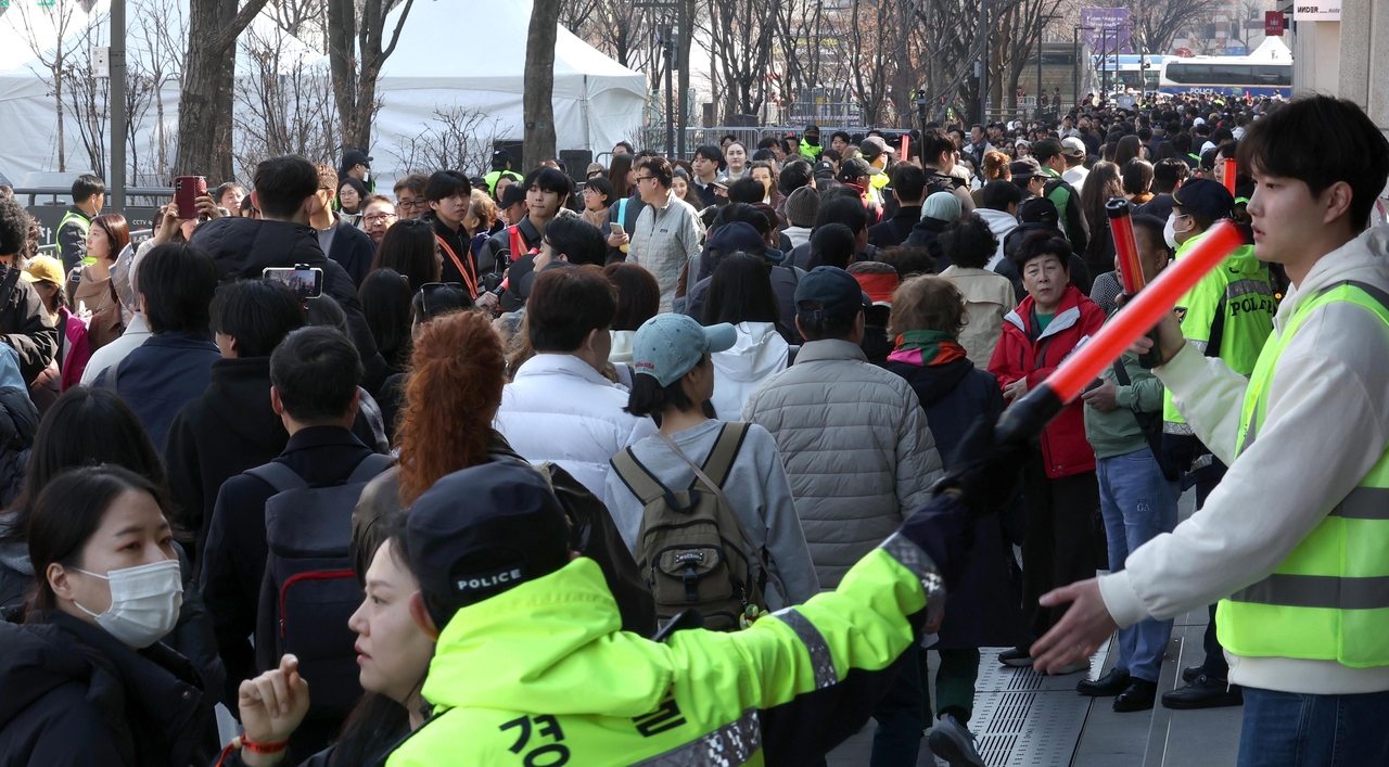 Crowds walk in one direction under police control to enter Gwanghwamun Square in Seoul on March 21, where BTS’ comeback show was held. (Lee Sang-sup/The Korea Herald)
