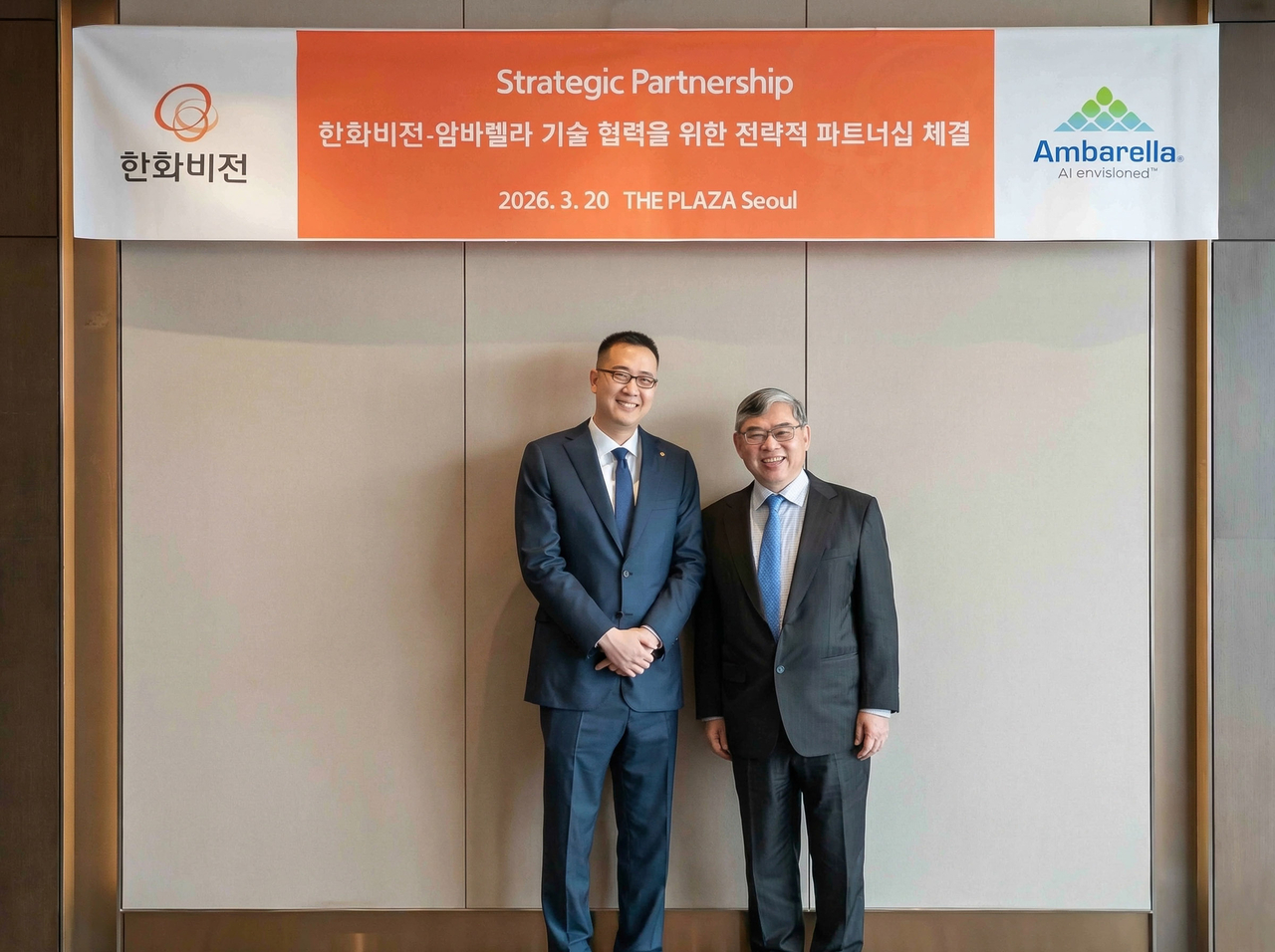 Kim Dong-sun (left), vice president of Hanwha Vision, and Fermi Wang, CEO of Ambarella, pose for a photo after signing a strategic partnership agreement at The Plaza Seoul on Friday. (Hanwha Vision)