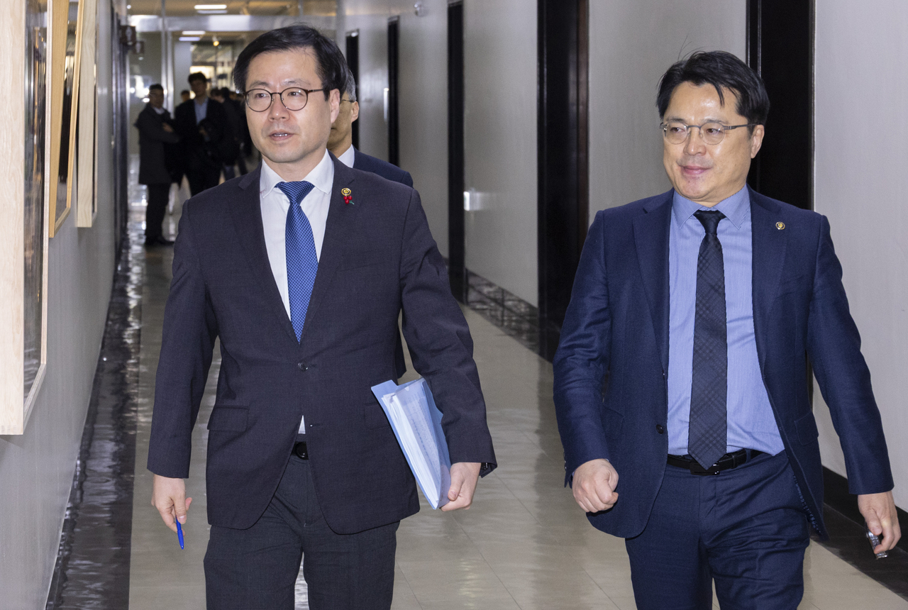 Yeo Han-koo (left), South Korea’s trade minister, and Industry Vice Minister Moon Shin-hak head to the chair’s office at the National Assembly’s Trade, Industry, Energy, SMEs and Startups Committee on Tuesday, after US President Donald Trump announced plans to raise tariffs, citing the South Korean legislature’s failure to complete legal procedures. (Yonhap)