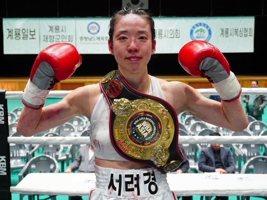 This photo, distributed by the Korean Boxing Commission, shows Seo Ryeo-kyung, a boxer and a professor of pediatrics at  Soonchunhyang University Cheonan Hospital, posing after being crowned the women's minimumweight champion Saturday. (Korean Boxing Commission)