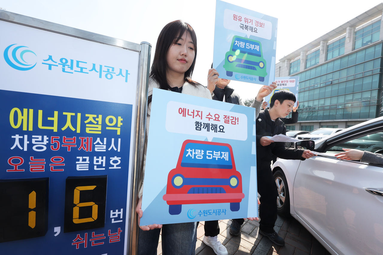 A promotion campaign for a car license plate restriction system is held in Suwon, just south of Seoul, on March 23. (Yonhap)