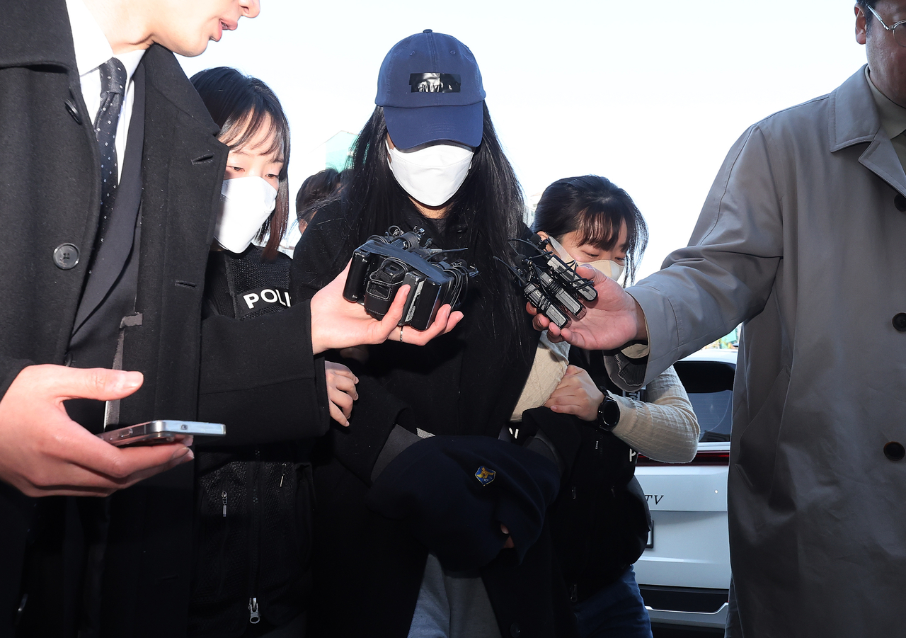 A woman (center) accused of abusing and killing her 3-year-old daughter attends an arrest warrant hearing at the Ansan branch of the Suwon District Court in Ansan, Gyeonggi Province, on March 19. (Yonhap)