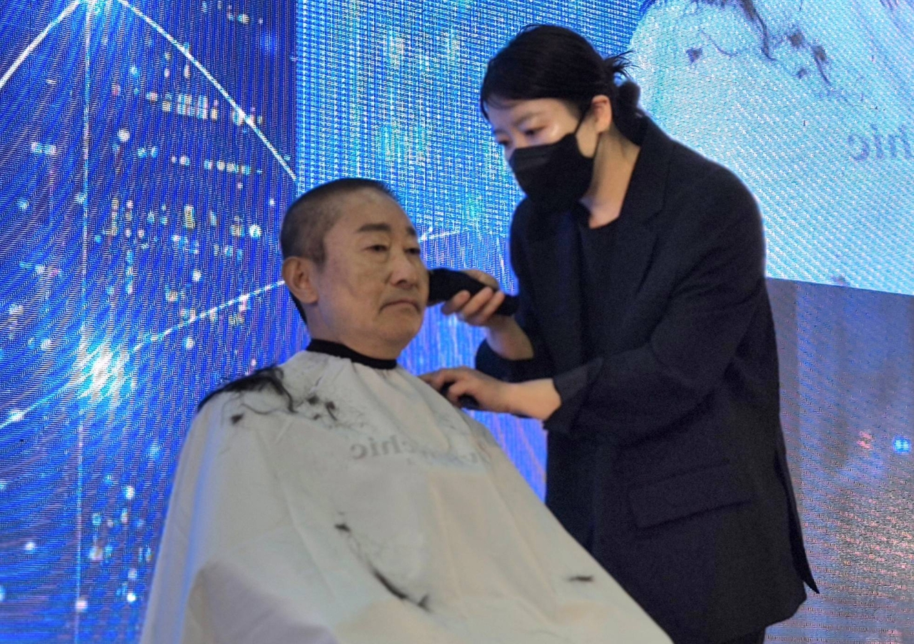 Democratic Party of Korea Rep. Park Beom-kye (left) has his head shaved during a rally event for supporters in Gongju, South Chungcheong Province, Feb. 28. (Yonhap)
