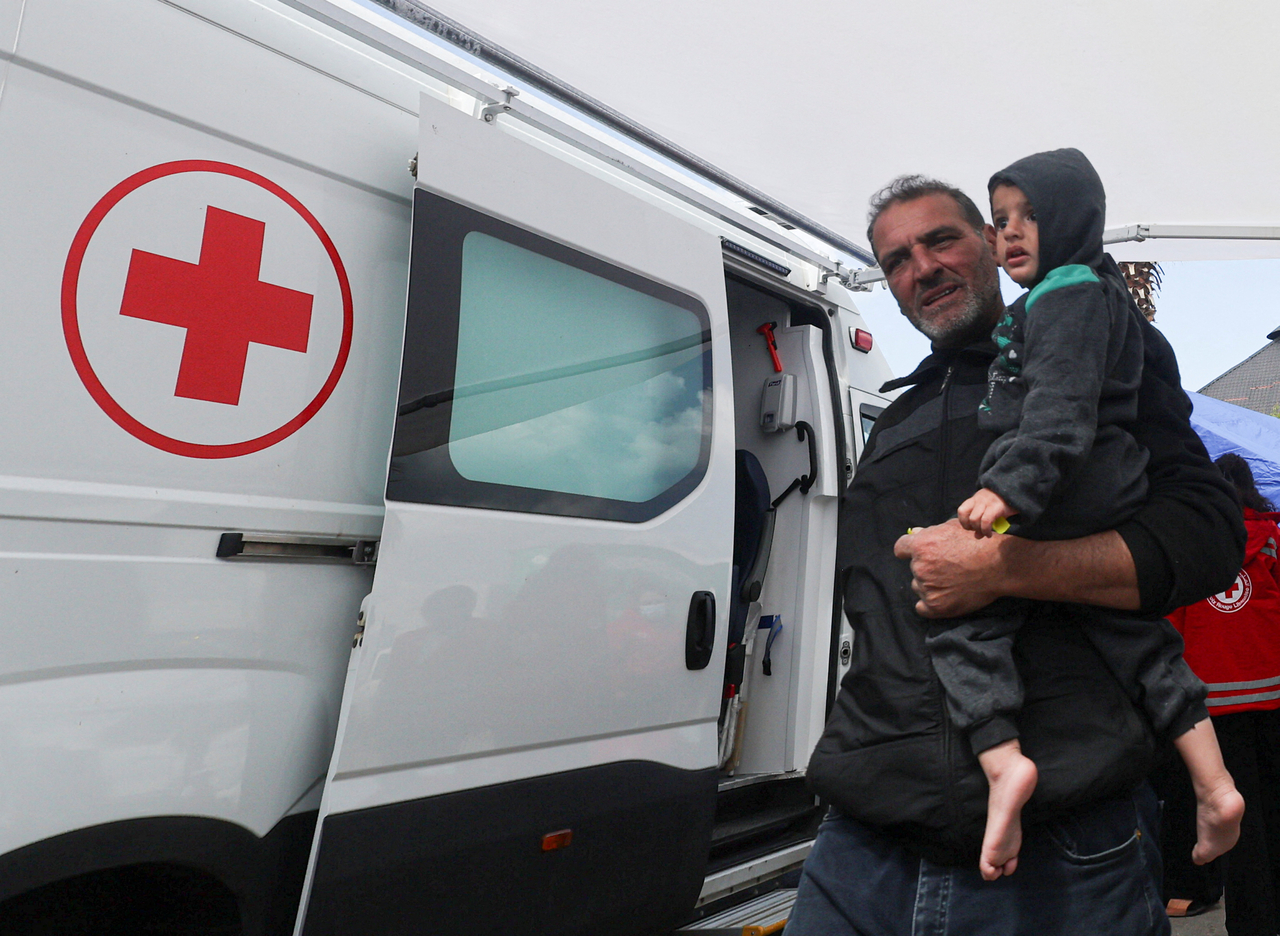 A displaced man carries his son after receiving medical assistance from the Lebanese Red Cross at a medical aid point supporting displaced people following an escalation between Hezbollah and Israel, in Beirut, march 16. (Reuters-Yonhap)