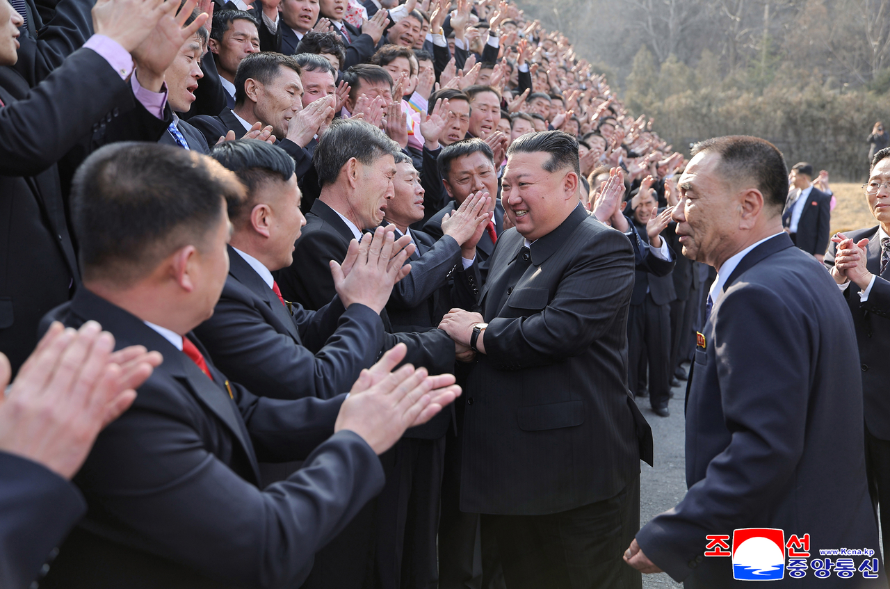 North Korean Supreme Leader Kim Jong-un (second from right) shakes hands with mine workers in South Pyongan Province on March 15. (Yonhap)