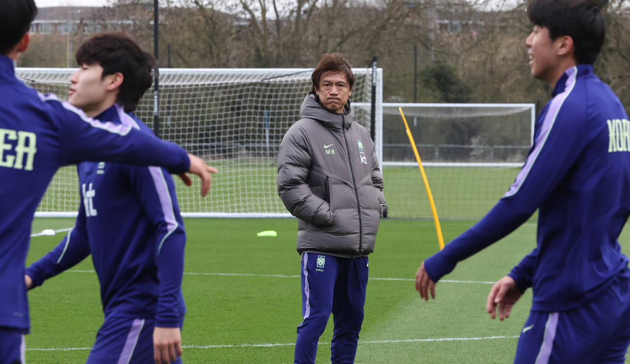 Hong Myung-bo (center), head coach of the South Korean men's national football team, watches his players during a training session at MK Dons training ground in Milton Keynes, England, on March 24, 2026. (Yonhap)