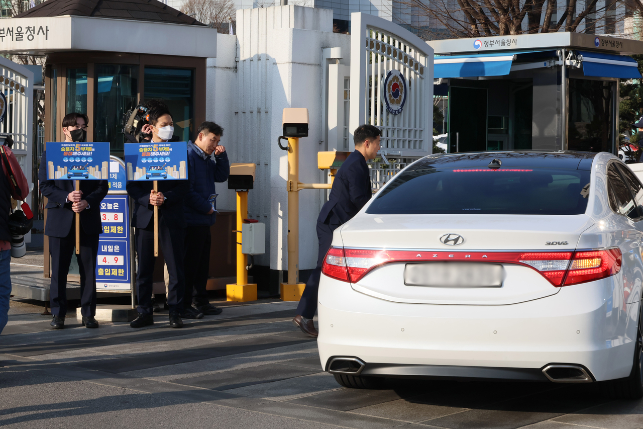 Officials hold signs Wednesday at the Government Complex Seoul, home to ministries including Foreign Affairs, to promote the five-day vehicle restriction campaign. (Yonhap)