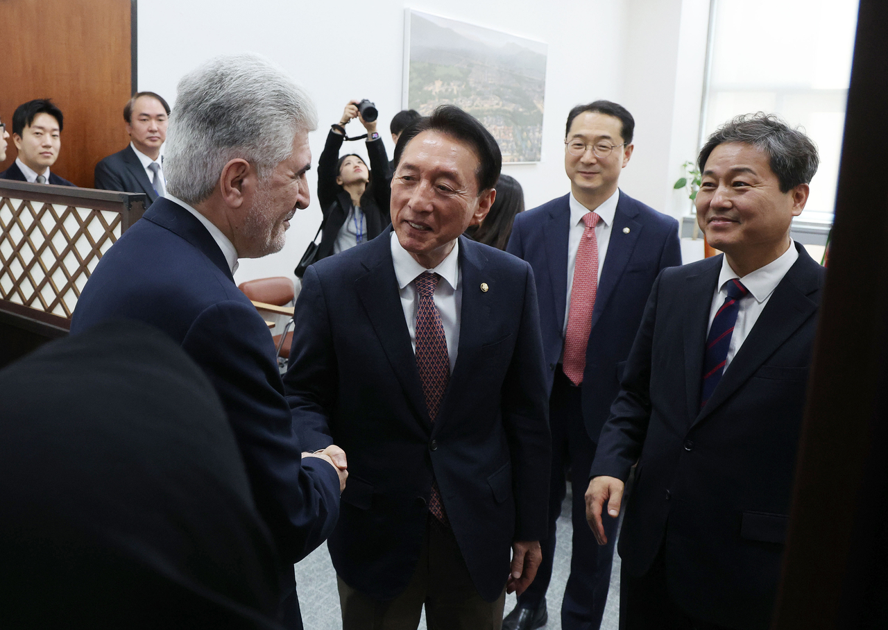 Iranian Ambassador to South Korea Saeed Koozechi (left) shakes hands with Rep. Kim Seok-ki (center) of the People Power Party, chair of the National Assembly’s Foreign Affairs and Unification Committee, at the National Assembly in Seoul on Wednesday. (Yonhap)