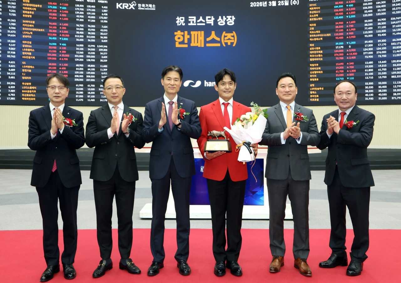 Hanpass CEO Kim Kyung-hoon (fourth from left) poses with officials at a listing ceremony held at the Korea Exchange in Yeouido, western Seoul, Wednesday. (Korea Exchange)