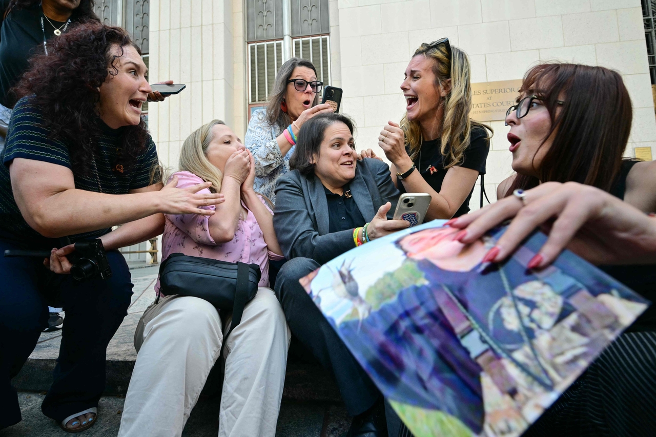 Laura Marquez-Garrett (center), plaintiffs' attorney for SMVLC, gathers with family members of victims as they react to news that the jury has found Meta and YouTube liable in the social media addiction trial, outside the Los Angeles Superior Court, in Los Angeles, Wednesday.   AFP-Yonhap
