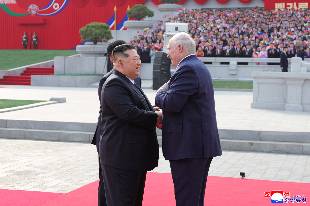 North Korean leader Kim Jong-un (left) meets Belarusian President Alexander Lukashenko at a welcoming ceremony held at Kim Il Sung Square on March 25, 2026, as Lukashenko has made his first official visit to North Korea, in this photo carried by North Korea's official Korean Central News Agency the following day.  (Yonhap)