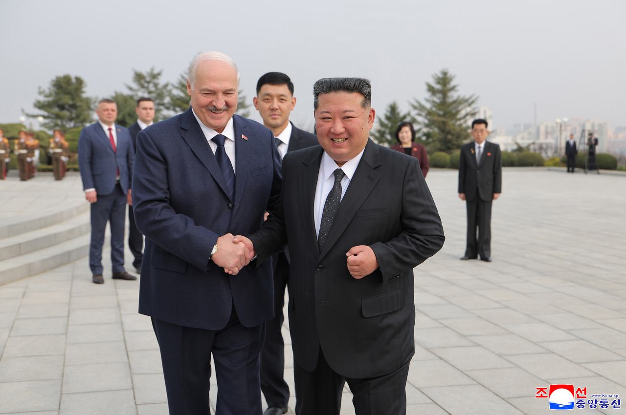 Belarusian President Alexander Lukashenko (left), who is on his first official visit to North Korea at the invitation of leader Kim Jong-un, shakes hands with Kim during a visit to the Liberation Tower honoring former Soviet soldiers in Pyongyang on Wednesday, according to the Korean Central News Agency. (KCNA-Yonhap)