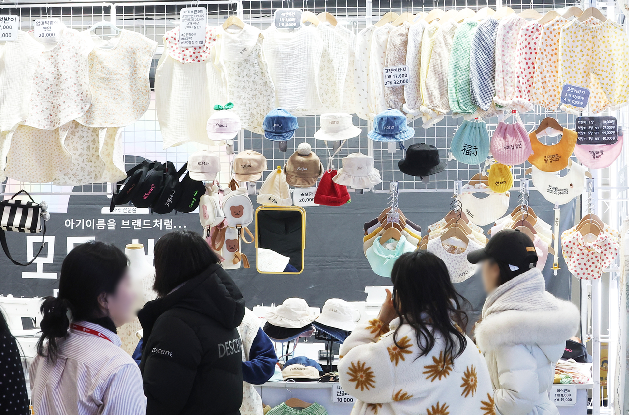 Parents browse baby clothes at an exhibition held in Suwon, Gyeonggi Province, Jan. 30. (Yonhap)