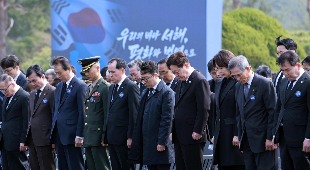 President Lee Jae Myung (fourth from right) observes a moment of silence during a ceremony marking West Sea Defense Day at Daejeon National Cemetery on Friday. (Yonhap)