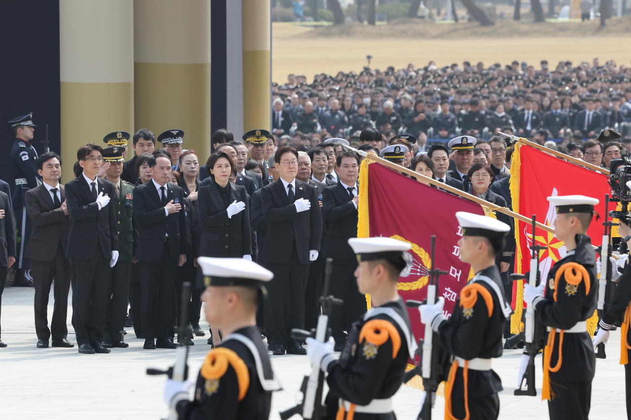 President Lee Jae Myung (center) salutes the national flag during a ceremony marking West Sea Defense Day at Daejeon National Cemetery on Friday. (Yonhap)