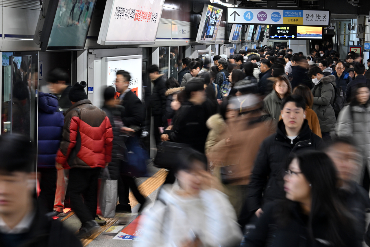 Passengers board a train at Seoul Station on Subway Line No. 4 on Feb. 19. (Im Se-jun/The Korea Herald)