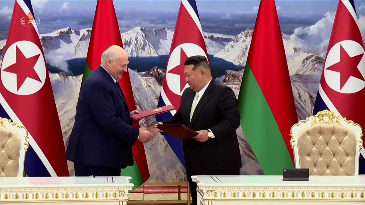 North Korean leader Kim Jong-un (right) exchanges documents on a treaty on friendship and cooperation with Belarusian President Alexander Lukashenko during their summit in Pyongyang on March 26, 2026. (Yonhap)