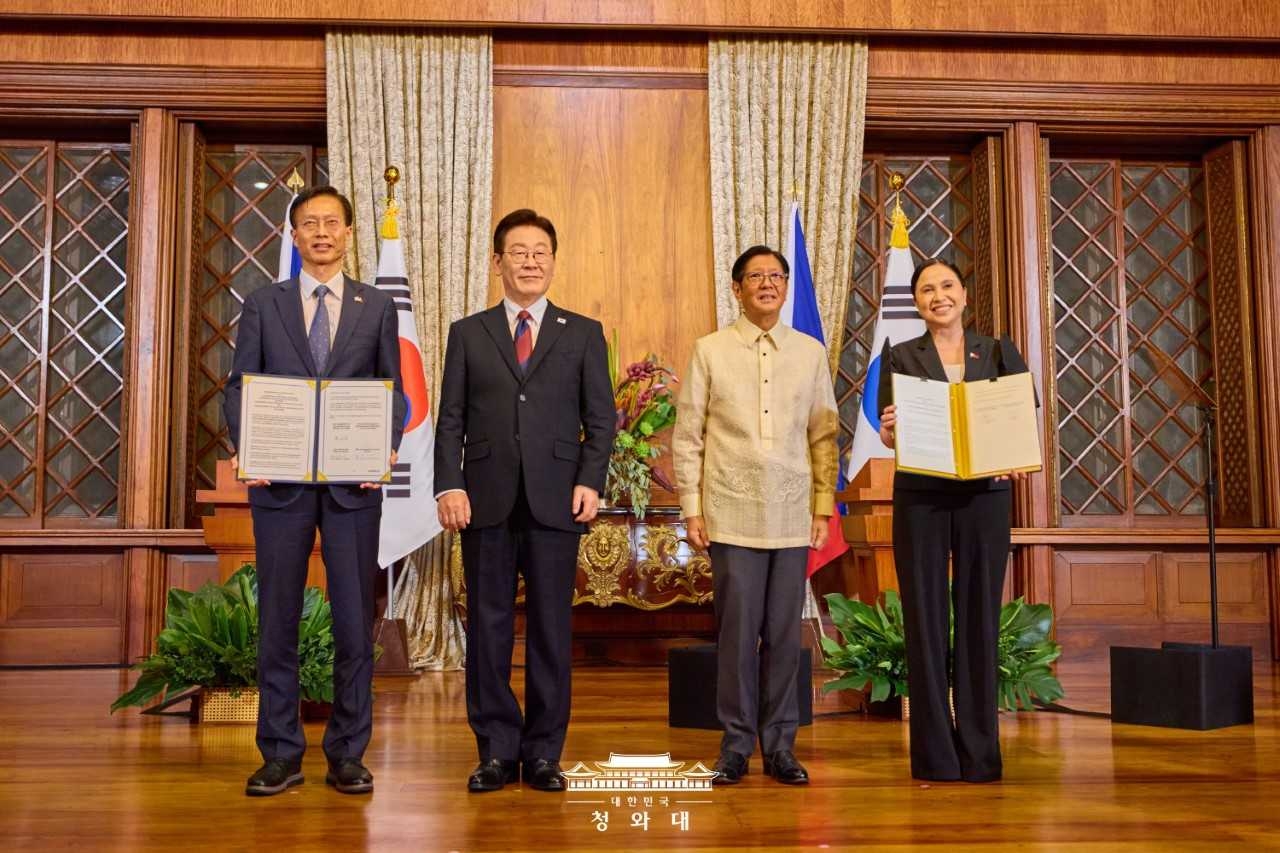 Intellectual Property Minister Kim Yong-sun (left) and Philippine Trade and Industry Secretary Maria Cristina Aldeguer Roque (right) pose for a photo after signing a revised memorandum of understanding on enhanced cooperation in intellectual property in the presence of President Lee Jae Myung (center left) and Philippine President Ferdinand Marcos Jr. at Malacanang Palace in Manila on March 3. (Cheongwadae)