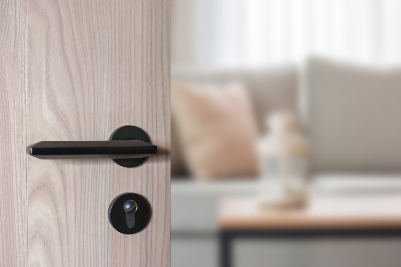 A residential door is seen partially open, revealing the interior of a living space. (123rf)