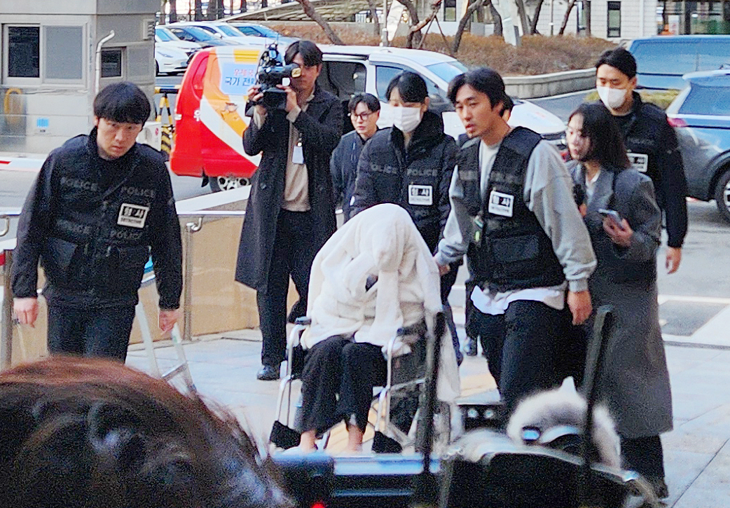 A woman in her 30s enters the Seoul Western District Court on Feb. 27 for a warrant review after being arrested on charges of driving her Porsche SUV under the influence of drugs two days earlier. (Yonhap)