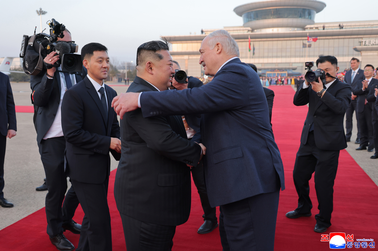 North Korean leader Kim Jong-un (left) shakes hands with Belarusian President Alexander Lukashenko on March 26, the final day of Lukashenko’s two-day visit to Pyongyang. (KCNA via Yonhap)