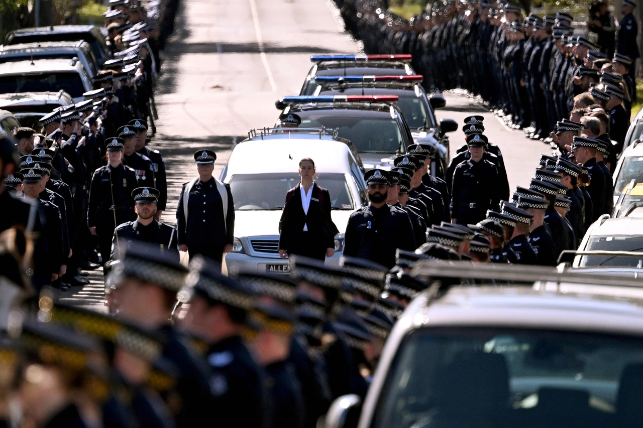 A police guard of honour salutes as the coffin of Senior Constable Vadim de Waart-Hottart, one of two officers shot dead by a fugitive gunman, is transported in a funeral procession in Melbourne in September 2025. (AFP-Yonhap)