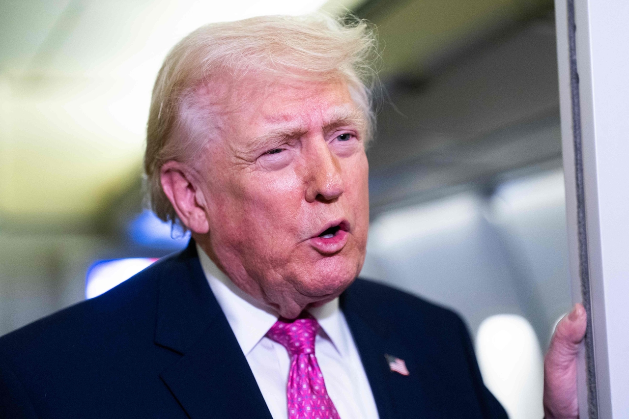 US President Donald Trump speaks with members of the media onboard Air Force One on Sunday while en route to Joint Base Andrews, Maryland from West Palm Beach Florida. (AFP-Yonhap)