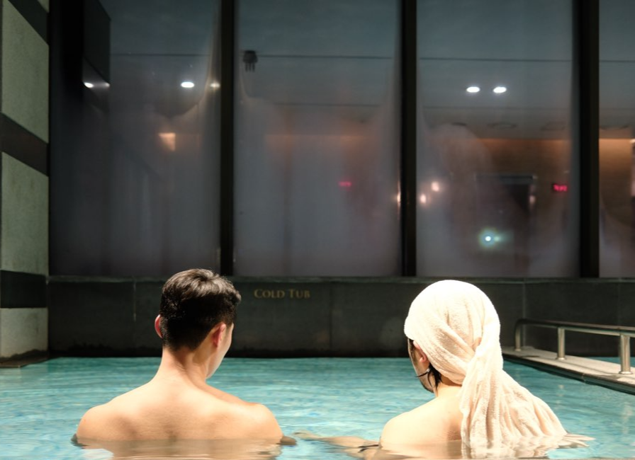 Two men sit in a cold plunge after a “sauna coffee chat” event co-hosted by mondaysauna and the Seoul Morning Coffee Club at Seoul Dragon City in Yongsan-gu on Feb. 23. (mondaysauna)
