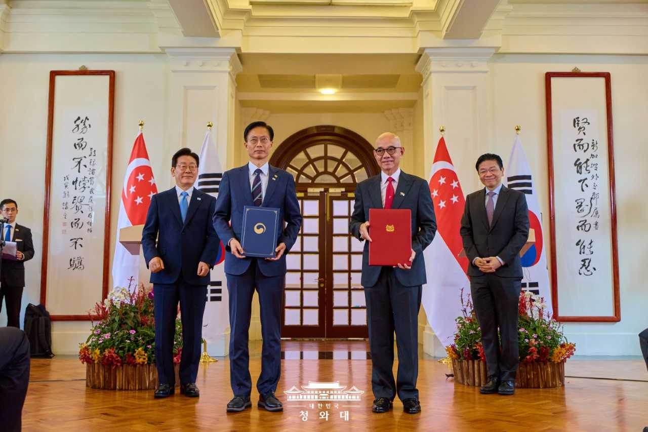 Intellectual Property Minister Kim Yong-sun (center left) and Nicky Tan, chairman of the Intellectual Property Office of Singapore (center right), pose for a photo after exchanging a memorandum of understanding on strengthened intellectual property cooperation at Singapore’s Ministry of Foreign Affairs on March 2, in the presence of President Lee Jae Myung and Singaporean Prime Minister Lawrence Wong. (Cheongwadae)
