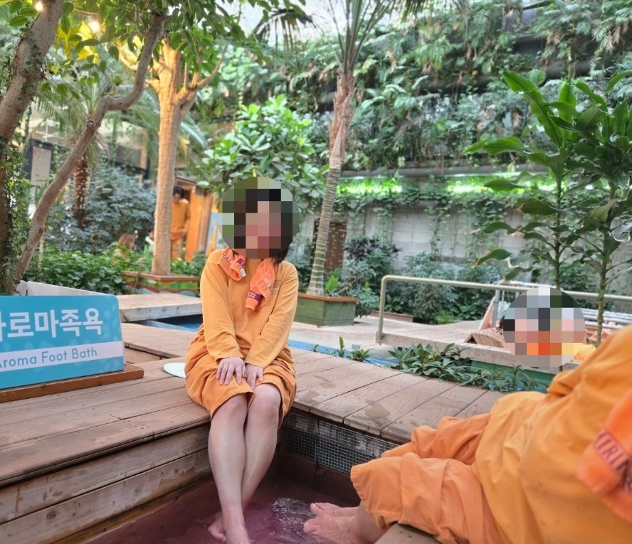 Jeong, dressed in typical jjimjilbang attire, enjoys an open-air foot bath at a bathhouse in Nonhyeon-dong, Seoul. (Jeong)