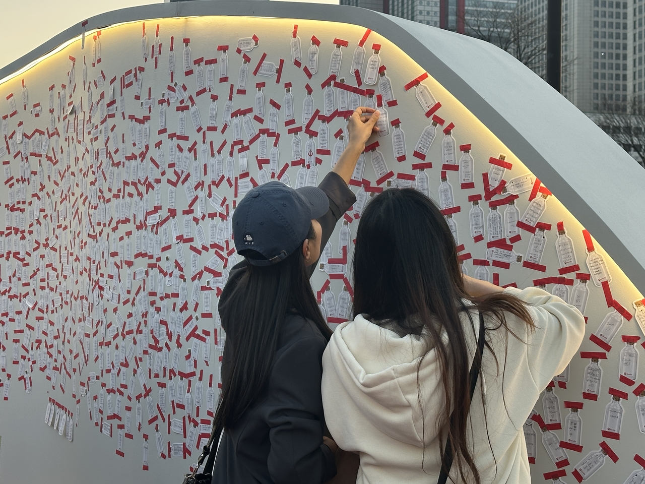 Fans write notes of support to BTS at the message wall installed at the Spotify Lighthouse pop-up event at Yeouido Hangang Park in western Seoul, Saturday. (Lee Jung-joo/The Korea Herald)