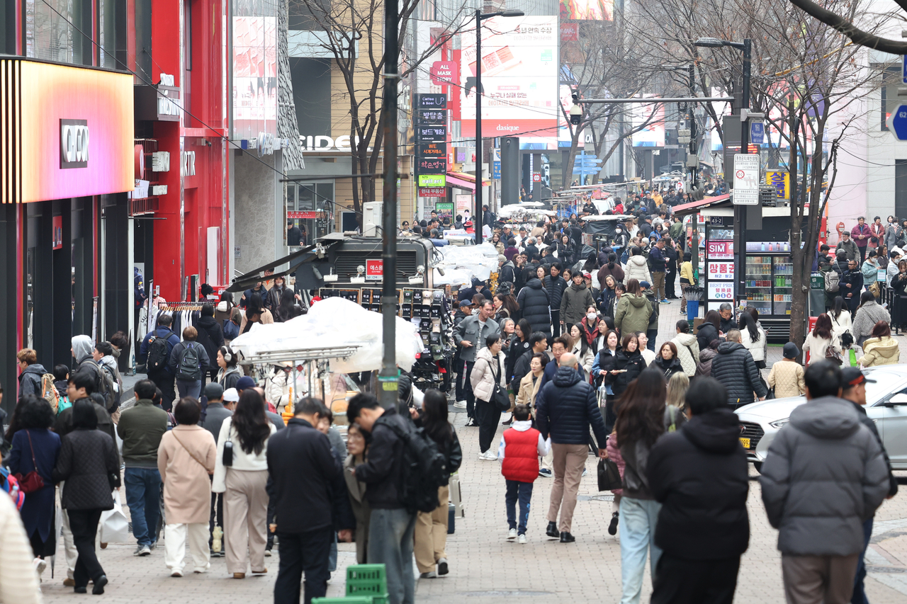 Tourists walk around Myeong-dong in central Seoul in this file photo taken on March 15. (Yonhap)