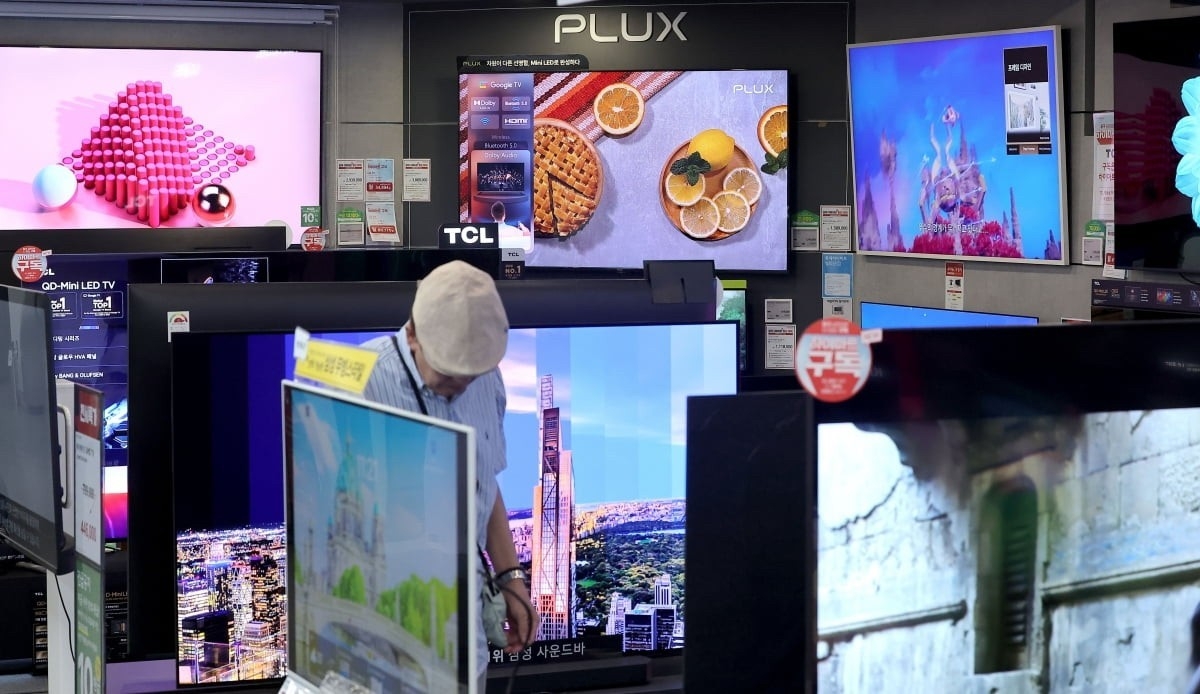 A shopper browses TVs at an electronics store in Seoul. ()