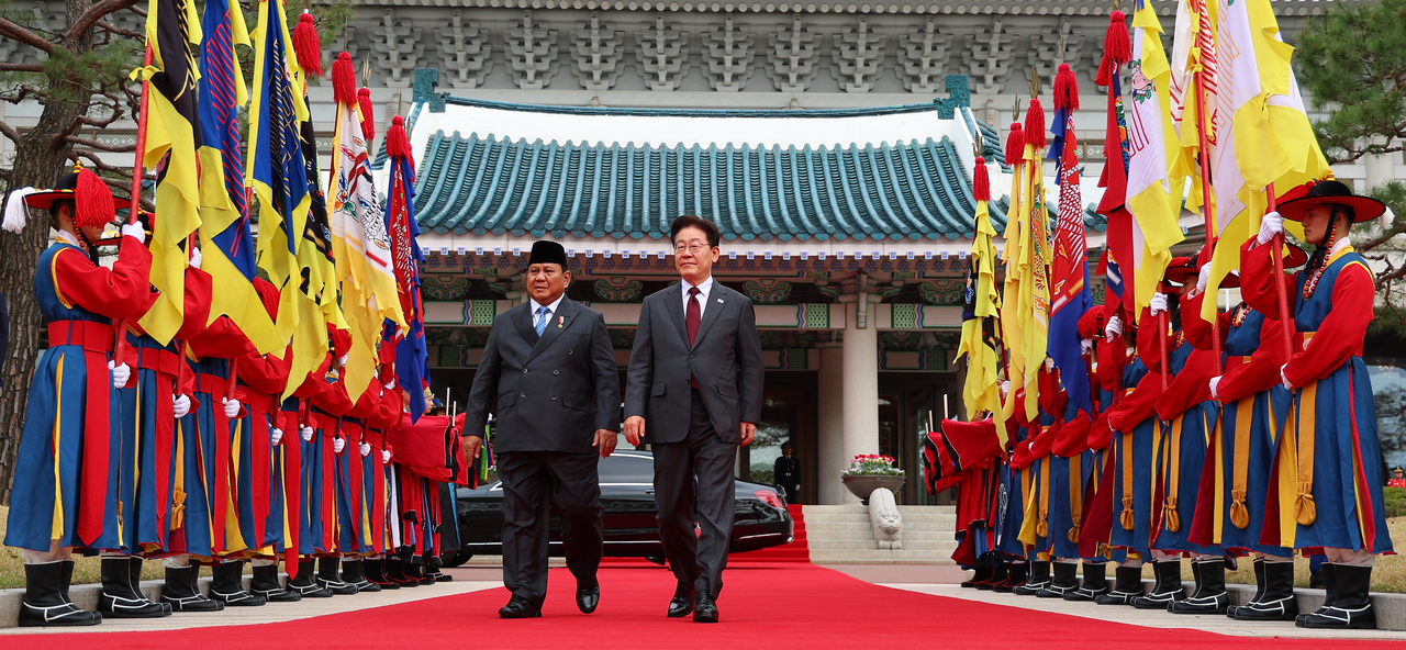President Lee Jae Myung walks with Indonesian President Prabowo Subianto to the official welcoming ceremony during Prabowo’s state visit at Cheong Wa Dae on Wednesday. (Yonhap)