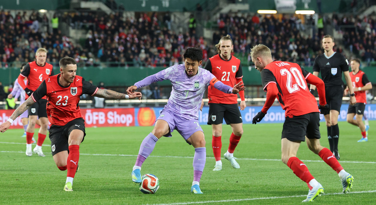 Son Heung-min of South Korea (center) is defended by Marco Friedl (left) and Konrad Laimer of Austria during the teams' friendly football match at Ernst-Happel-Stadion in Vienna on March 31, 2026. (Yonhap)
