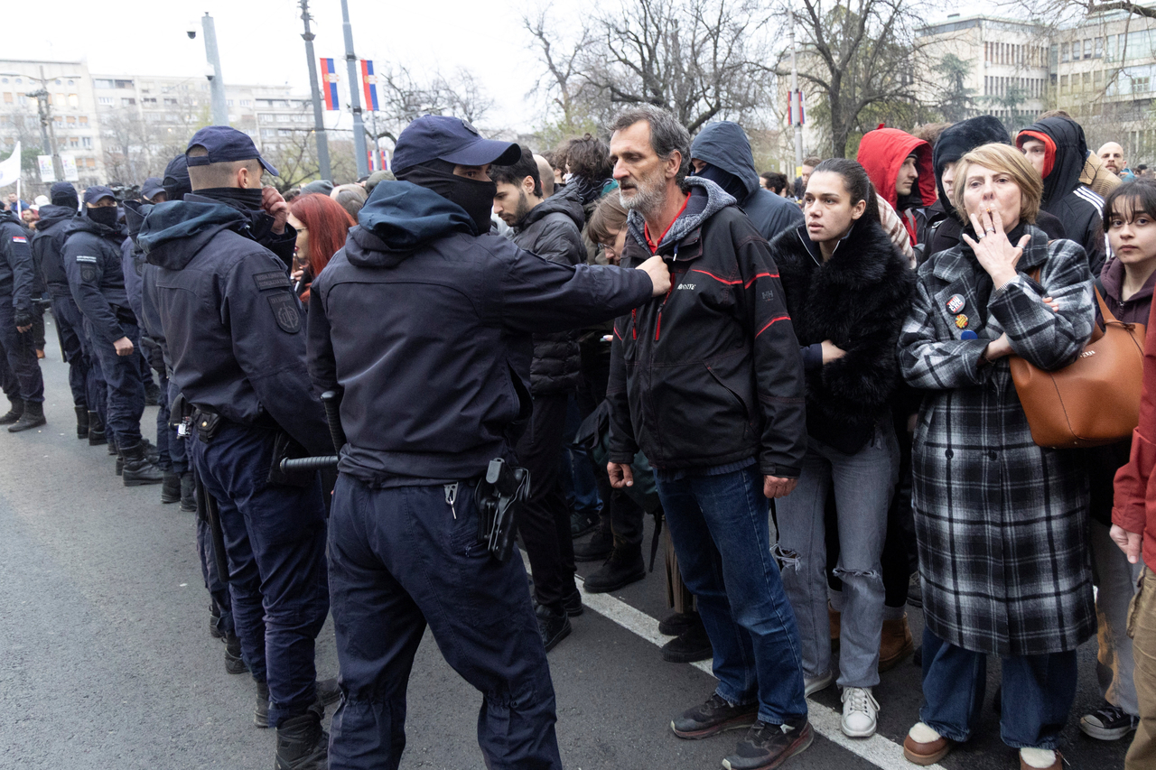 Serbian police officers stand guard as people rally to protest police search of Belgrade's university offices after the accidental death of a student, in Belgrade, Serbia, Tuesday. (Reuters-Yonhap)