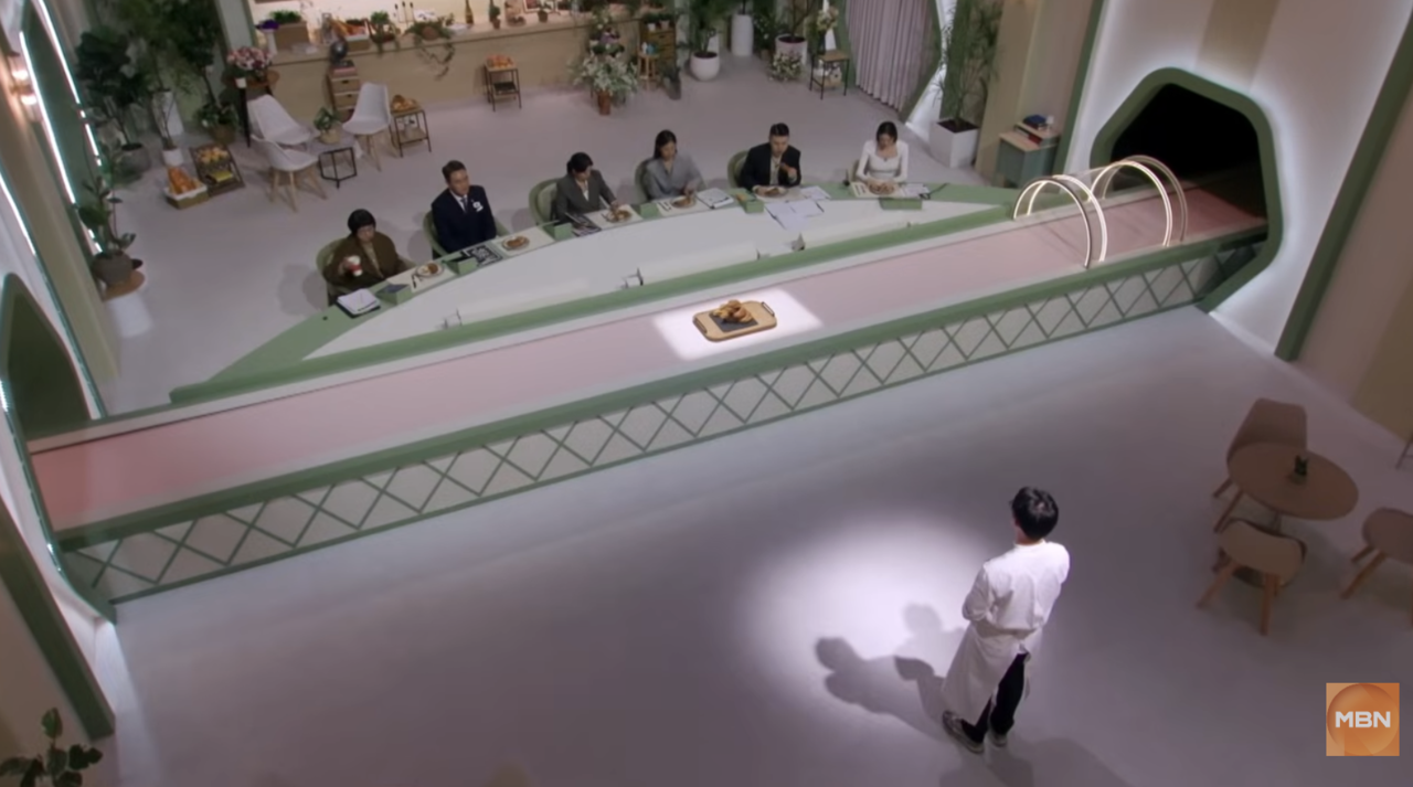 A contestant presents his bread for judging on "Cheonha Bakery: Bake Your Dream." (MBN)