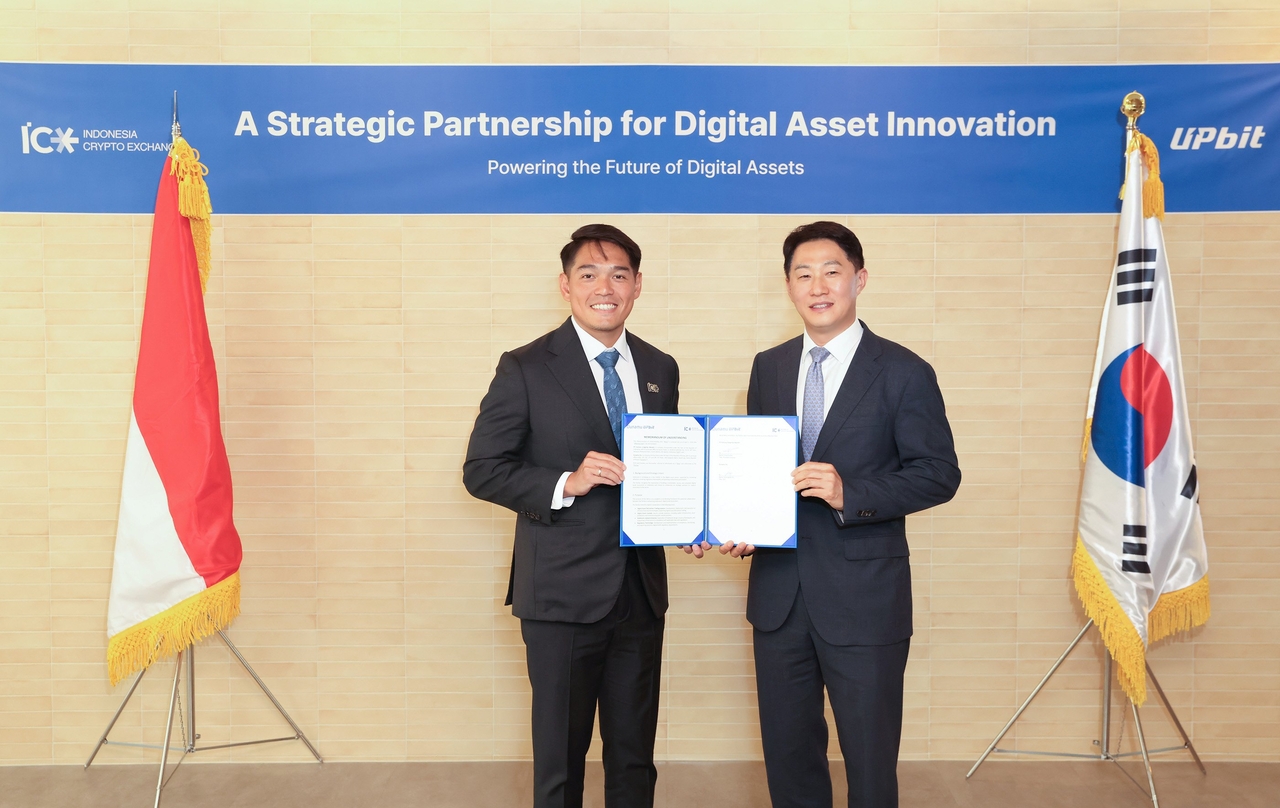 Dunamu CEO Oh Kyoung-suk (right) and ICEx CEO Pang Xue Kai pose for a picture during a signing ceremony held in Seoul, Wednesday. (Dunamu)