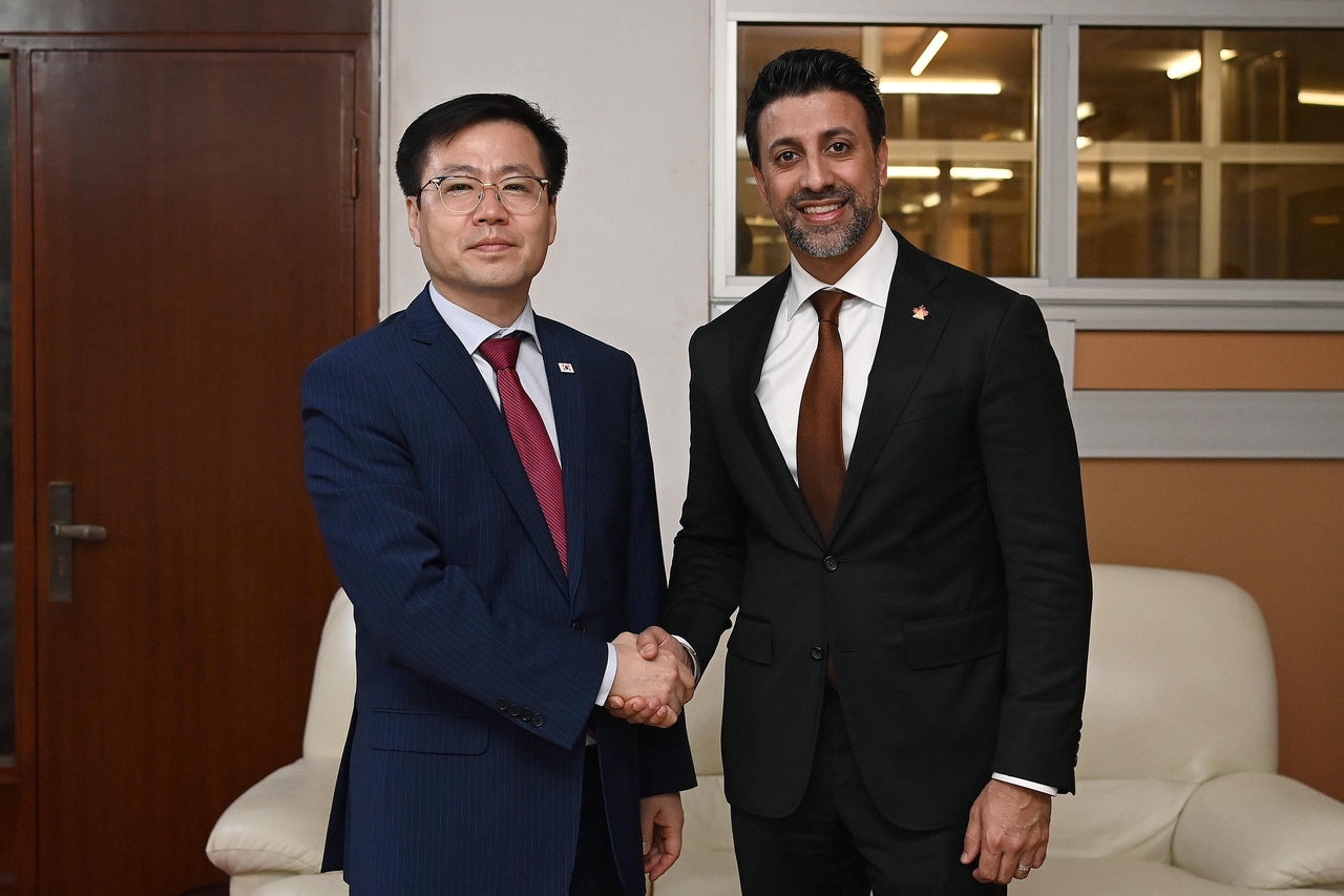 South Korea's Trade Minister Yeo Han-koo poses for a photo with Maninder Sidhu, Canada’s minister of international trade, during their meeting on the sidelines of the 14th Ministerial Conference in Cameroon, Saturday. (Ministry of Trade, Industry and Resources)