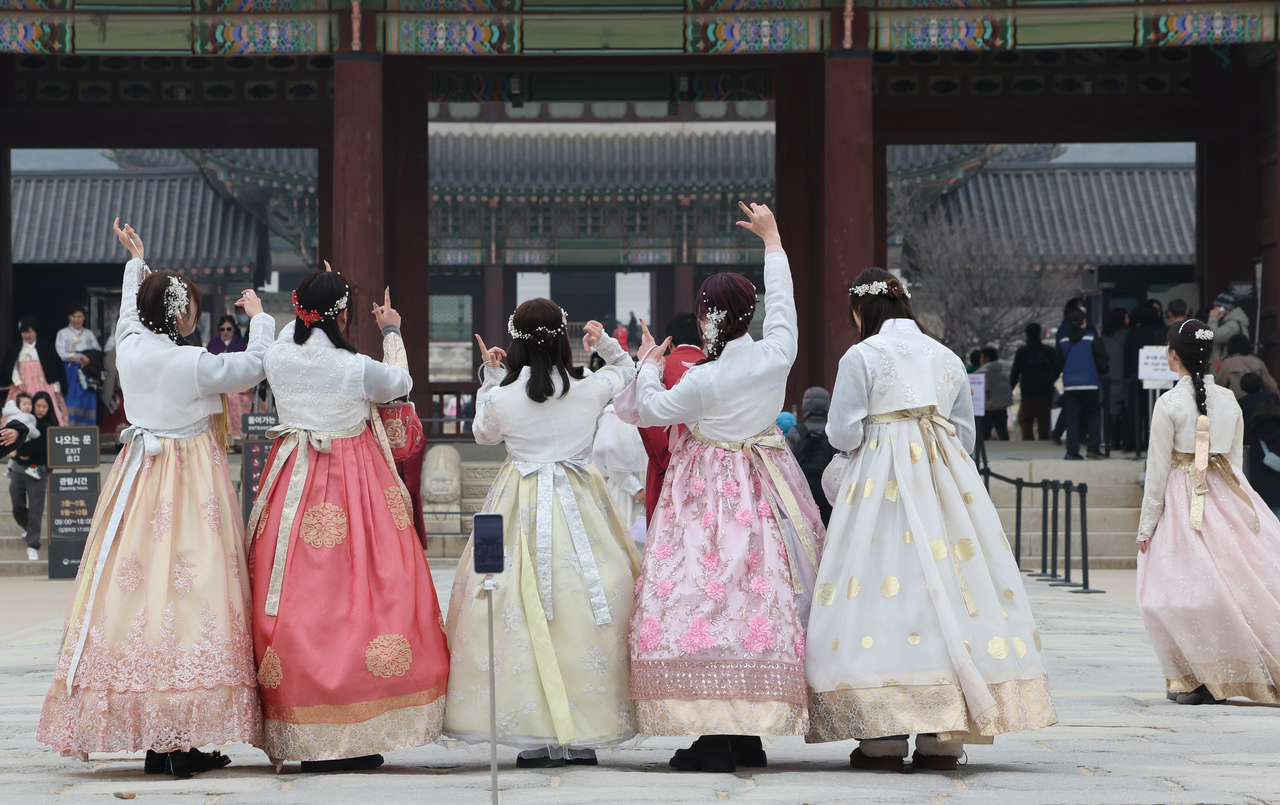 Visitors are seen clad in traditional Korean hanbok at Gyeongbokgung in Seoul on March 15. (Yonhap)