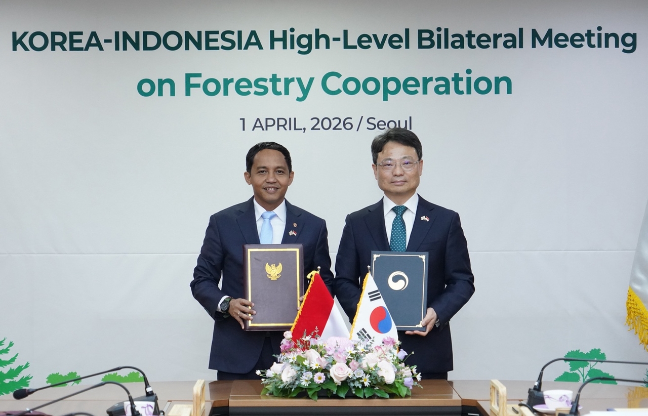 Minister of the Korea Forest Service Park Eun-sik (right) and Indonesia's Forestry Minister Raja Juli Antoni pose for a photo after signing a memorandum of understanding in Seoul on Wednesday. (Korea Forest Service)