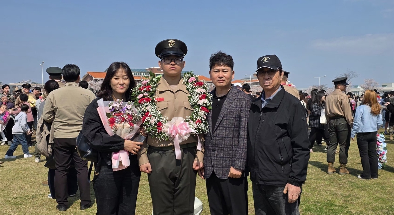 Pvt. Kim Jun-young (second from left) of the 1,327th Marine recruit class poses with family at a ceremony marking completion of training in Pohang, North Gyeongsang Province, Thursday. (Yonhap)