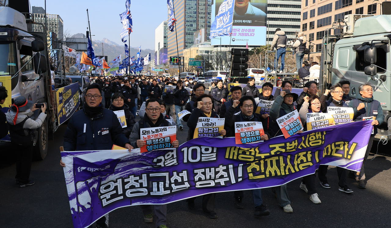 Members of the Korean Confederation of Trade Unions march with placards demanding that contractors negotiate with subcontracted workers at a rally in Seoul on March 10. (Yonhap)