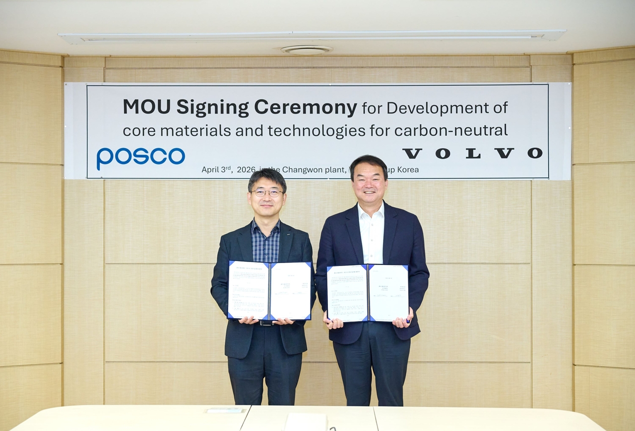 Kang Ho-jin (right), vice president of the R&D section at Volvo Construction Equipment, and Lee Kyu-young, head of the steel solution research center at Posco Research Lab, pose for a photo at a signing cermony at Volvo's plant in Changwon, South Gyeongsang Province, Friday. (Volvo Construction Equipment)