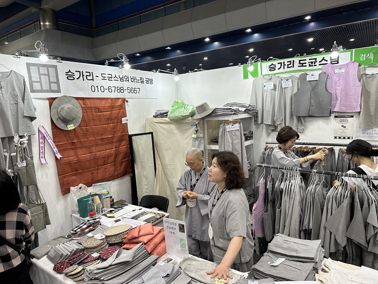 Rhythm, Faith, and Technology: 250,000 Attend Buddhism Expo, Driven by Gen Z Enthusiasm 25 Ven. Dogyun of Hyegwangsa (left, background) stands at her booth showcasing handmade monastic items at the 2026 Seoul International Buddhism Expo. (Tammy Park/The Korea Herald)
