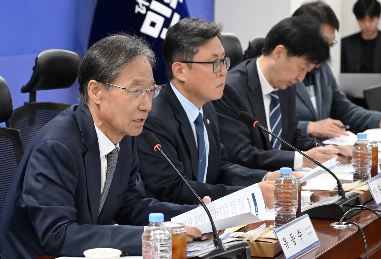Reps. Yoo Dong-soo (left) and Ahn Do-geol (second from left) are seen during a meeting of Democratic Party lawmakers and the vice ministerial government officials at the National Assembly on Monday. (Lee Sang-sub/The Korea Herald)