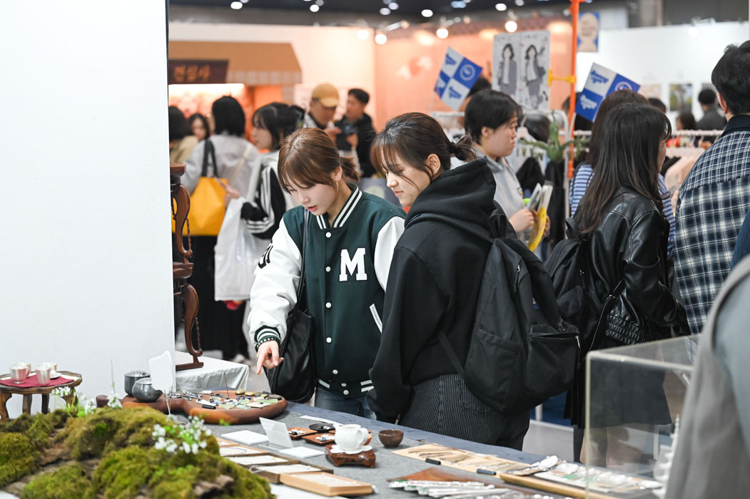 Rhythm, Faith, and Technology: 250,000 Attend Buddhism Expo, Driven by Gen Z Enthusiasm 28 Two young visitors examine teaware items at a booth at the 2026 Seoul International Buddhism Expo. (Seoul International Buddhism Expo 2026)