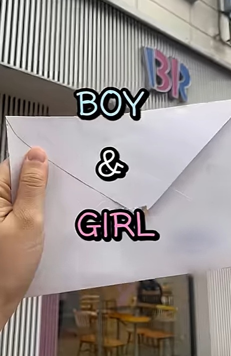 An expectant mother holds a doctor’s note revealing her baby’s gender outside a Baskin-Robbins store before handing it to an employee. (@nemosemofamily, YouTube)