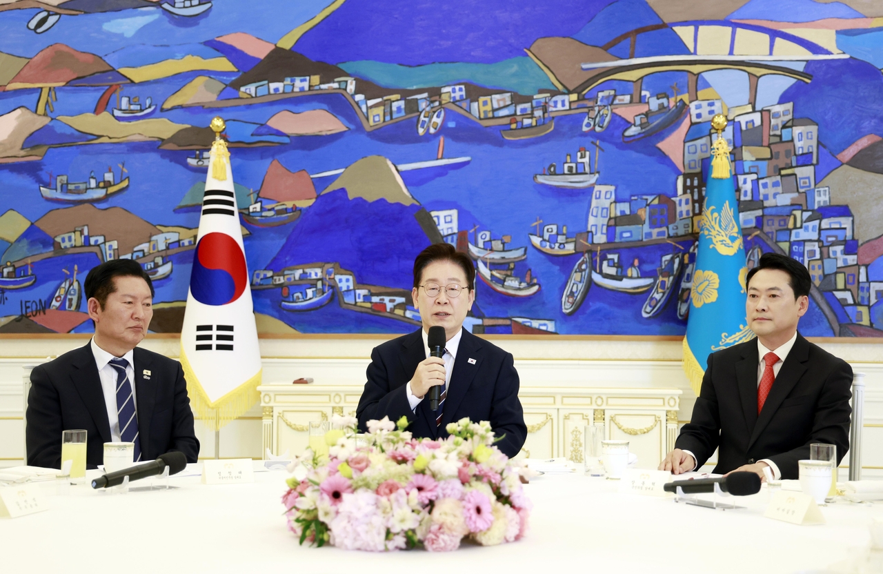 President Lee Jae Myung (center) speaks during a tripartite consultative meeting on the economy at Cheong Wa Dae in Seoul on Tuesday, joined by ruling Democratic Party of Korea leader Rep. Jung Chung-rae (left) and main opposition People Power Party leader Rep. Jang Dong-hyeok. (Yonhap)